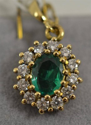 Lot 384 - An 18ct gold emerald and diamond pendant, the oval mixed cut emerald within a border of round...