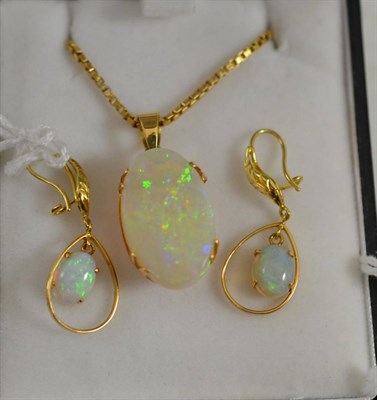 Lot 401 - An opal pendant on chain, the oval polished opal in a yellow claw mount, hung on a box link...