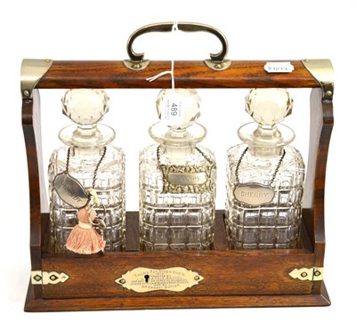 Lot 489 - An oak silver plated presentation three bottle tantalus, dated 1910