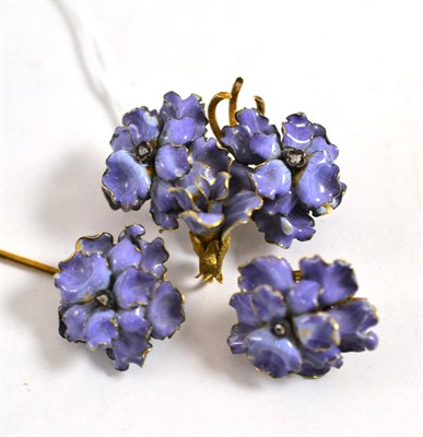 Lot 584 - Two floral brooches and one pin, circa 1890, each enamelled in purple, with a rose cut diamond...