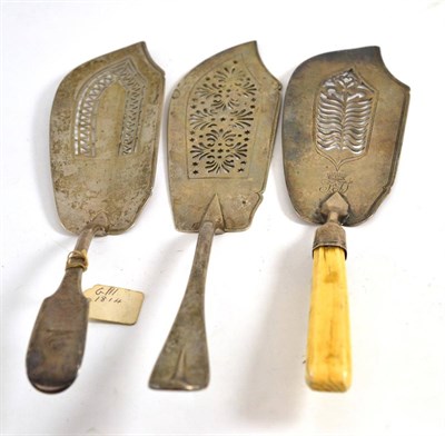 Lot 597 - Three George III silver fish slices, one with ivory handle