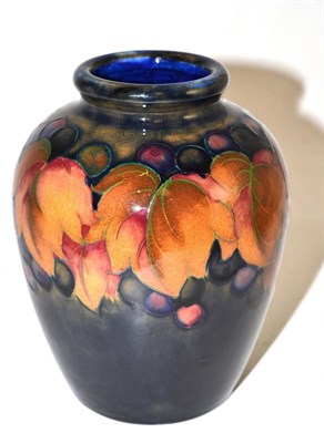 Lot 692 - A Walter Moorcroft Leaf and Grape pattern baluster vase, on a blue ground, impressed factory...