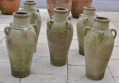 Lot 1351 - Set of five olive jar planters, 81cm high