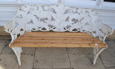 Lot 1360 - A Coalbrookdale style cast iron garden bench, cast and pierced with ferns and strapwork, slat seat