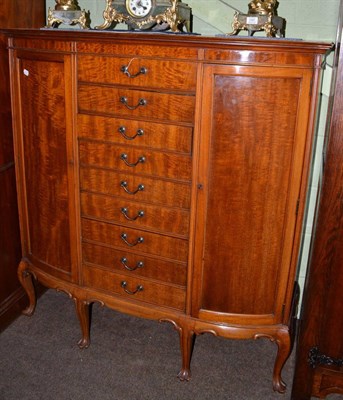 Lot 1396 - A mahogany D-shaped cabinet with two cupboard doors, the centre section fitted with nine...