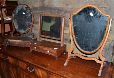 Lot 1408 - Two George III mahogany toilet mirrors and a later shield shaped toilet mirror