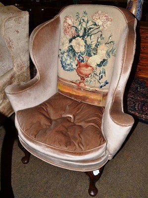 Lot 1452 - Walnut wing armchair, basically 18th century, in brown velvet with tapestry panel to back, with...