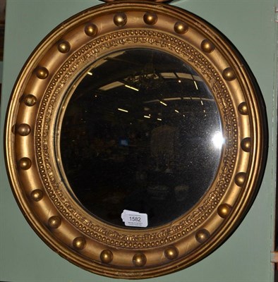 Lot 1582 - A gilt convex mirror with ball surmounted frame