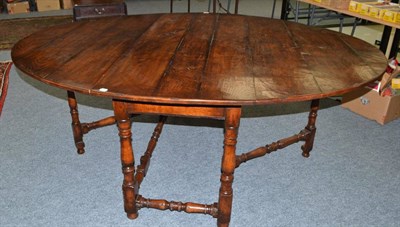 Lot 1619 - An oak eight seater drop leaf table on turned supports and a George III corner cupboard