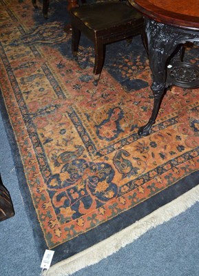 Lot 1659 - Machine made carpet, the indigo field with urns issuing flowers around a floral medallion framed by