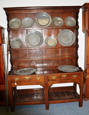 Lot 1686 - An early 19th century joined oak dresser, the rack with three shelves with iron cup hooks, the base