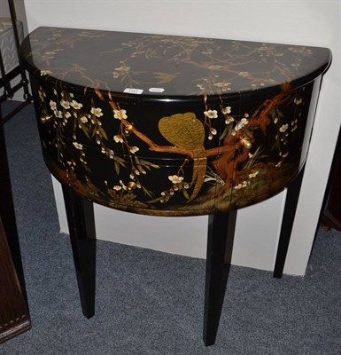 Lot 1751 - A black lacquered demi-lune cabinet fitted with two drawers and two cupboard doors