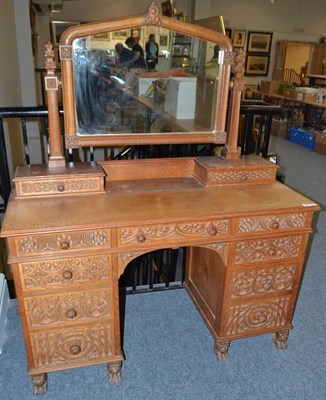 Lot 1810 - A carved oak Gothic Revival dressing table, the shaped rectangular mirror in a carved frame...