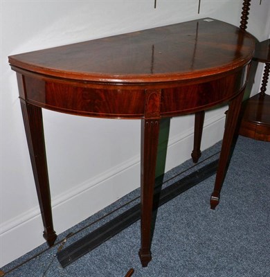 Lot 1823 - A George III style mahogany fold-over card table on square fluted legs