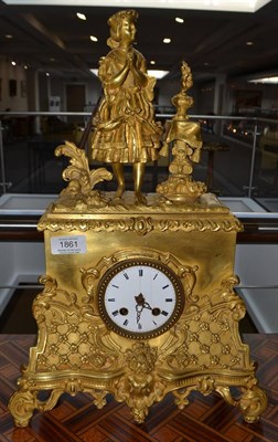 Lot 1861 - A gilt metal striking mantel clock, circa 1890, surmounted by a lady in costume, 3-inch enamel...