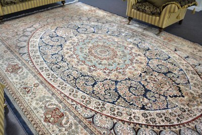 Lot 1867 - A good machine made artificial silk carpet of Oriental design, the deep indigo oval field with...