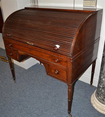 Lot 1877 - A late Regency mahogany roll front desk, 2nd quarter 19th century, the tambour front enclosing...