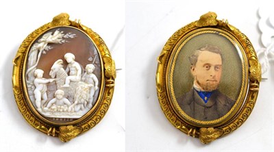 Lot 34 - A cameo/locket swivel brooch, the carved shell cameo depicting a pastoral scene with a goat and...