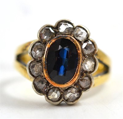 Lot 82 - A synthetic sapphire and diamond cluster ring, the oval mixed cut sapphire in a yellow rubbed...