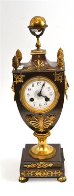 Lot 95 - An urn shaped gilt metal mounted striking mantel clock, surmounted by a globe and applied gilt...