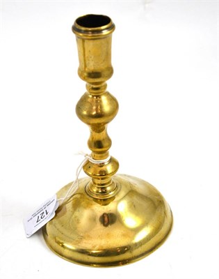 Lot 127 - A late 17th century brass candlestick, circa 1680, on a low domed foot with an inverted...