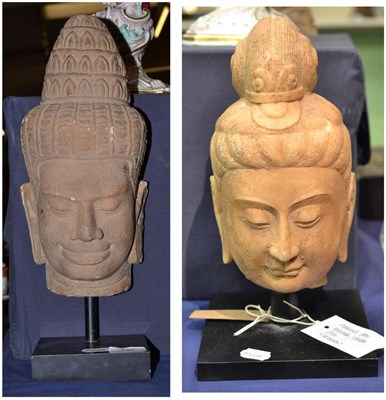 Lot 145 - Two Indian carved stone Buddha heads on metal display stand, 36cm and 34cm high (2)