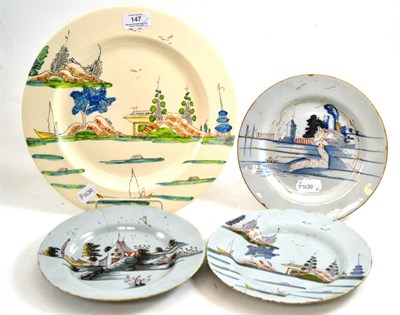 Lot 147 - An English Delft plate, painted in colours with a European landscape, 22cm diameter, two...