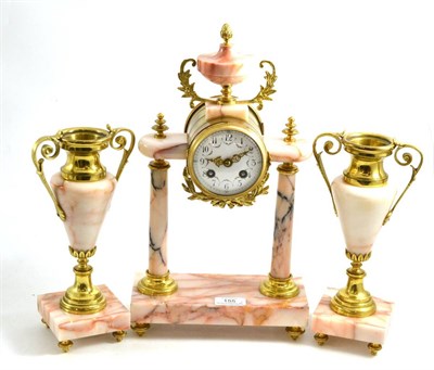 Lot 155 - A pink marble and gilt metal mounted striking mantel clock with garniture, circa 1910, portico...