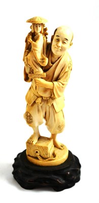 Lot 177 - A Japanese ivory okimono, Meiji Period, of a man holding a figure of a girl on a hardwood base,...