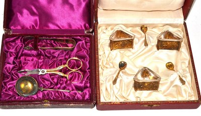 Lot 180 - Cased set of three gilt salts and spoons and cased tongs, scissors and spoon set