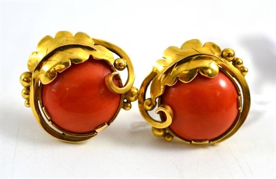 Lot 255 - A pair of coral earrings, a round cabochon coral within a bead and foliate motif frame, with...