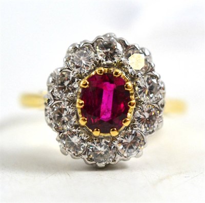 Lot 261 - A ruby and diamond cluster ring, the oval mixed cut ruby within a border of round brilliant cut...