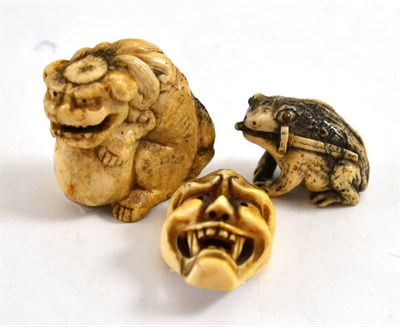 Lot 277 - Three early 20th century Japanese carved ivory netsukes modelled as a frog, a carved mask and a...