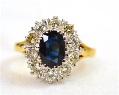 Lot 344 - An 18ct gold sapphire and diamond cluster ring, an oval cut sapphire within a border of round...