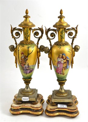 Lot 479 - A pair of Victorian gilt metal urns decorated with Classical figures, raised on giltwood bases,...