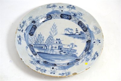 Lot 510 - * An 18th century Delft tin glazed plate decorated with a landscape, 30cm wide