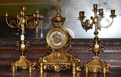 Lot 568 - A gilt metal striking mantel clock with garniture, circa 1900, case depicting swag, scroll, dolphin