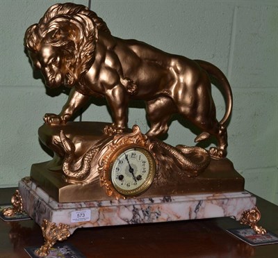 Lot 573 - A marble and gilt metal striking mantel clock, circa 1910, surmounted by a lion looking at a snake