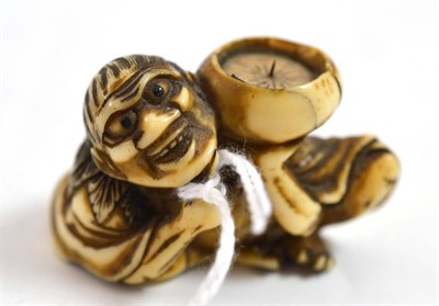 Lot 595 - A Japanese carved ivory netsuke, circa 1900, modelled as a squatting man pointing to his...