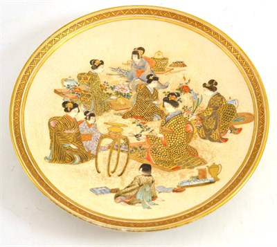 Lot 607 - A Satsuma pottery plate, circa 1890, decorated with eight women and younger girls seated...