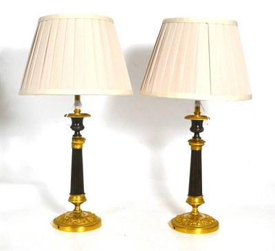 Lot 719 - A pair of French parcel gilt bronze table candlesticks, in Restoration style, each with campana...