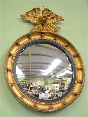 Lot 1245 - Circular mirror with eagle surmount, 62cm high by 47cm wide