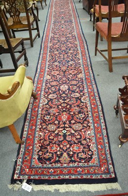 Lot 1337 - Narrow Saroukh runner, West Persia, the indigo field of scrolling vines and palmettes enclosed...