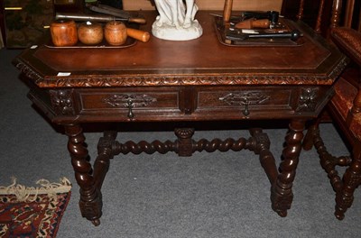 Lot 1415 - A carved oak writing table/ library table, inset with two drawers, red leather writing surface