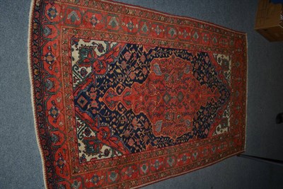 Lot 1433 - Saroukh rug, West Persia, circa 1920, the deep indigo field of angular vines centred by tomato...