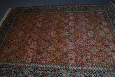 Lot 1441 - Ghom style carpet, Indian, the terracotta lattice field of Mayfield inspired plants enclosed by...