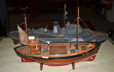 Lot 1470 - A grey painted model of a Naval war boat, 140cm wide, together with a model of a trawler boat