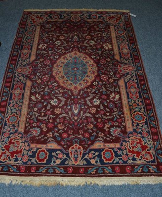 Lot 1619 - Amritzar rug, Punjab, the deep claret field of flowering vines around a sky blue cusped...