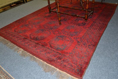 Lot 1633 - Afghan carpet, North West Afghanistan, the deep claret field with three columns of elephant...