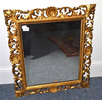 Lot 1648 - A Florentine style carved giltwood framed wall mirror, with a pierced roccaille and scroll border